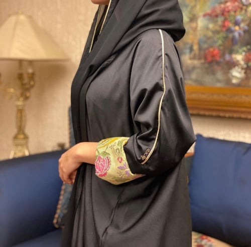 عباية سوداء بأكمام خضراء موردة