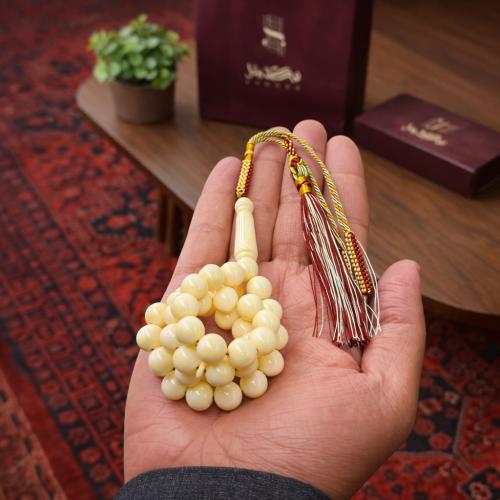 A prayer bead with a clasp with a tassel with a small pendant