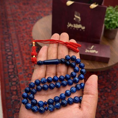 A prayer bead with a clasp with a tassel with a small pendant