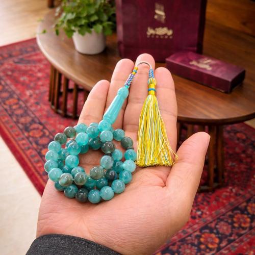 A prayer bead with a clasp with a tassel with a small pendant