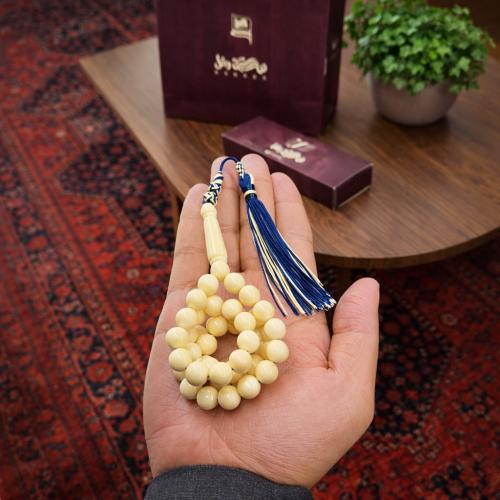 A prayer bead with a clasp with a tassel with a small pendant