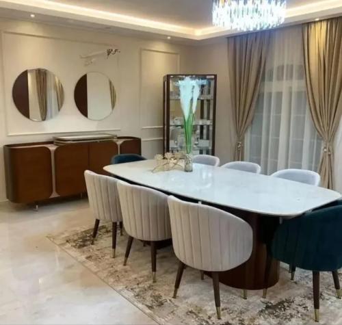 طاولة طعام فاخرة بسطح رخامي مستطيل مع 8 كراسٍ مخمل...