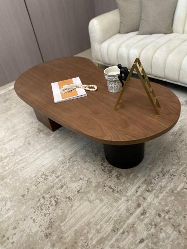 طاولة قهوة بتصميم بيضاوي و سطح بقشرة جوز طبيعية