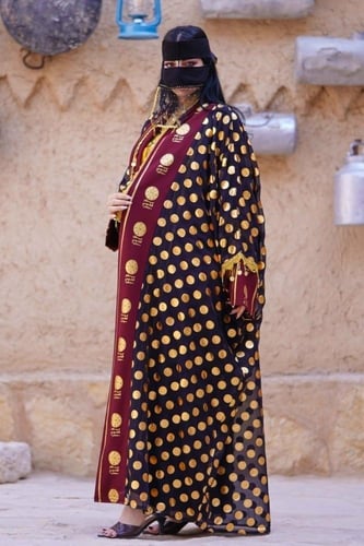 بشت اسود معا ياقه عنابي متزين بهوية يوم التاسيس