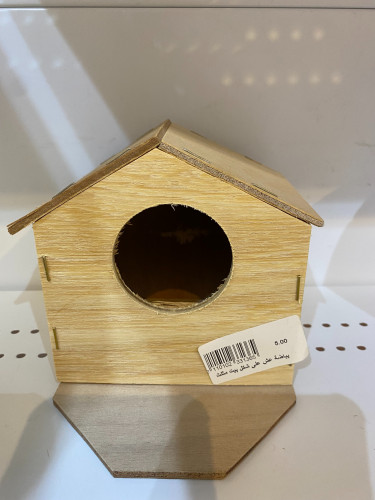 A birdhouse in the shape of a triangular house