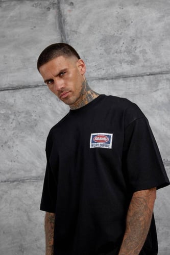 تيشيرت أسود اوفرسايز بطبعة من الخلف " BRAND WORLD...