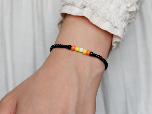 سوارة من الخرز بلون أصفر وبرتقالي