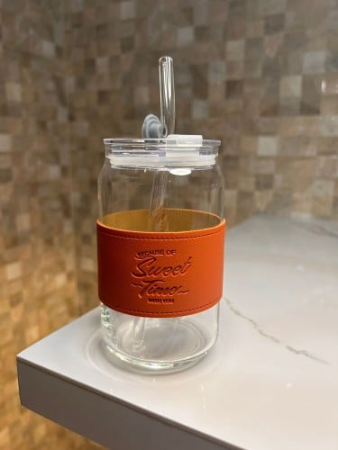 كوب زجاجي مع مصاص لون برتقالي