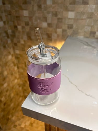 كوب زجاجي مع مصاص لون وردي