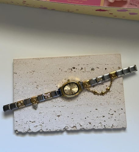 ساعة باللون الفضي والذهبي بتنسيق انيق