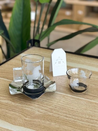 طقم شاهي وقهوة بصحن فضي وبقاعدة سوداء أنيقة