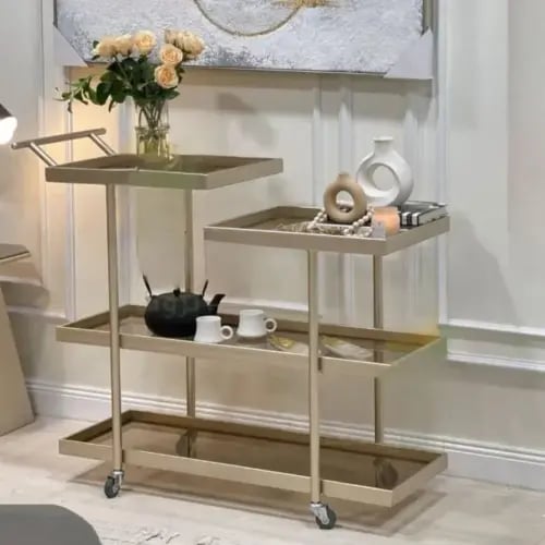 عربة ضيافة بلون و حواف ذهبي وسطح زجاج بني بتصميم ح...