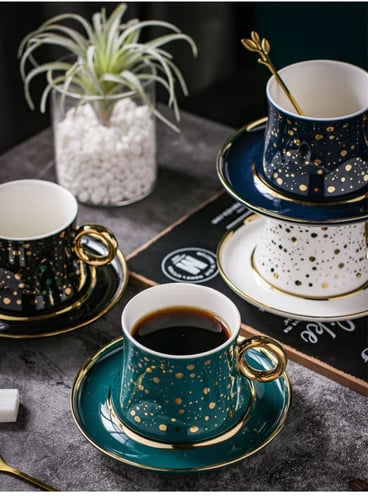 فنجان قهوة فاخر من السيراميك مع طبق تقديم وملعقة