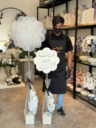 ستاند مناسبات عباره عن فازة ورد مع كتابه الاسم وفا...