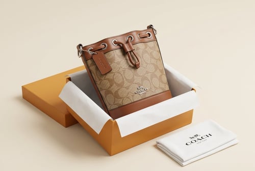 حقيبة باكيت نسائية أنيقة من Coach بنقشة Signature...