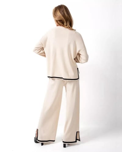 طقم نسائي بيج بلوزة وبنطال واسع بحواف سوداء