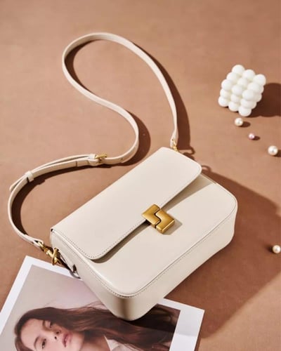 حقيبة كروس جلدية بيج فاتح بتصميم كلاسيكي وقفل ذهبي