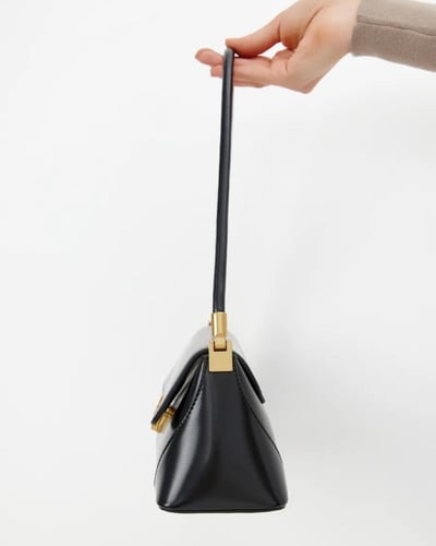 شنطة كتف جلد باللون الأسود بتفاصيل ذهبية أنيقة