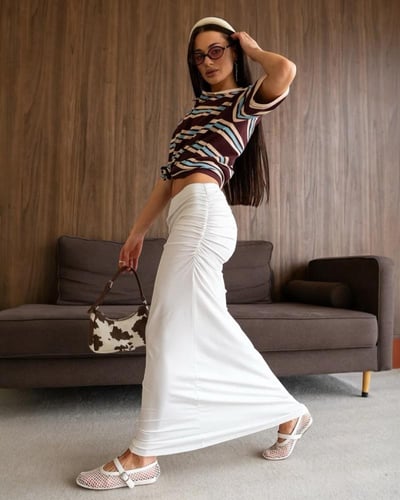 تنورة طويلة بيضاء بستايل مزموم جانبي وقصة انسيابية...