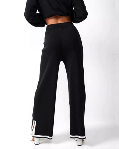 طقم نسائي أسود بلوزة وبنطال واسع بحواف بيضاء