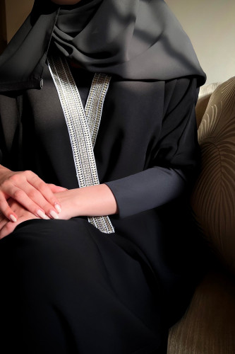 ‏Black abaya with silver collar.