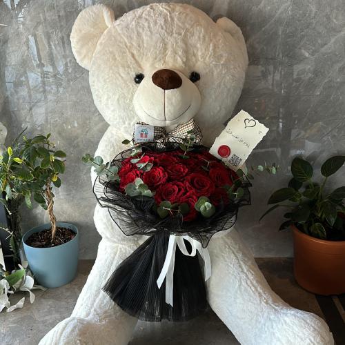 دبدوب كبير مع باقة ورود حمراء