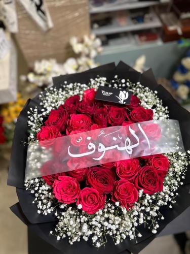 بوكيه جوري أحمر وجبسوفيلا بتغليف أسود مع شريط اسم...