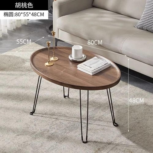 طقم طاولة قهوة وسط سطح خشبي واعمدة معدنية