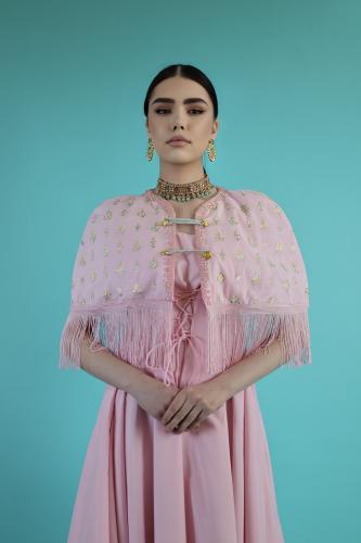 A dress with a distinctive design made of two pieces, a pink-colored dress and a piece with special details on the shoulders in th...