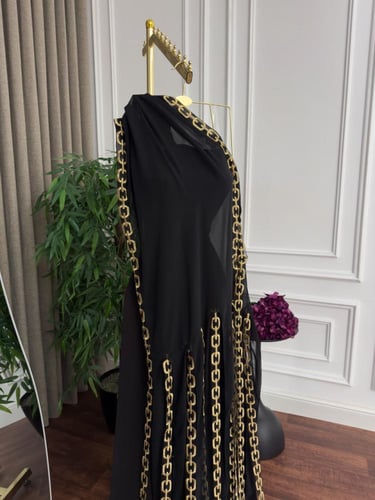 فستان سهرة أنيق باللون الأسود مزين بسلاسل ذهبية
