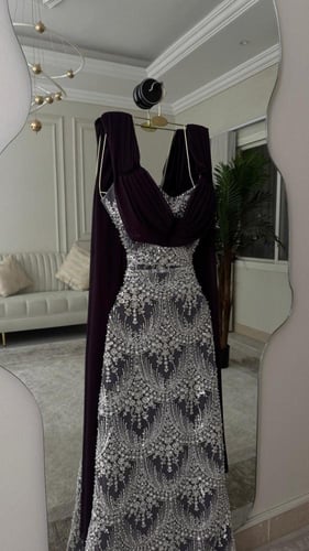 فستان سهرة فاخر بتطريز فضي لامع وكاب ملكي