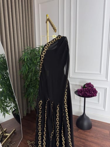 فستان سهرة أنيق باللون الأسود مزين بسلاسل ذهبية