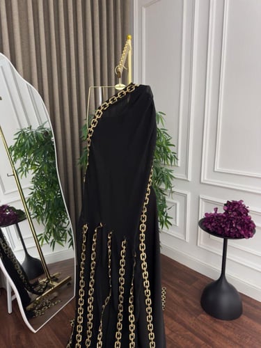 فستان سهرة أنيق باللون الأسود مزين بسلاسل ذهبية