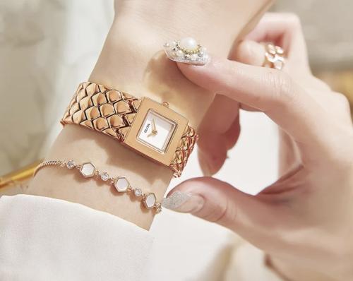 A gold watch with a white-colored dial