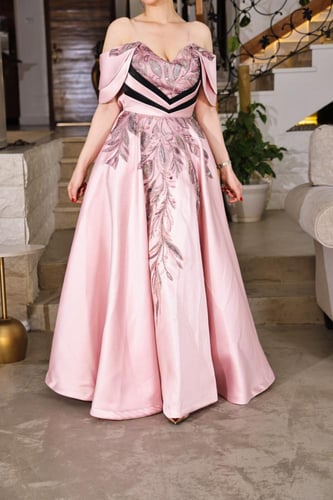 فستان سهرة وردي فاتح بتصميم فاخر وأكتاف مكشوفة