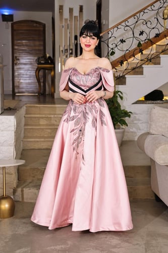 فستان سهرة وردي فاتح بتصميم فاخر وأكتاف مكشوفة