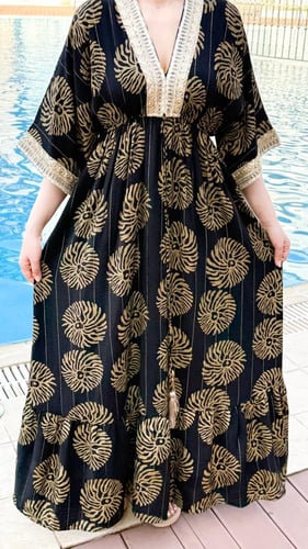 فستان طويل أسود مزخرف بنقوش ذهبية مع تصميم عصري