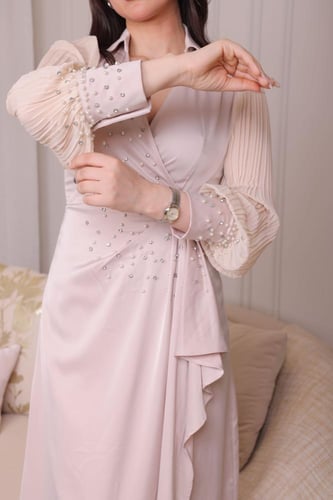 فستان متموج مع أكمام شفافة مزخرفة بالكريستالات