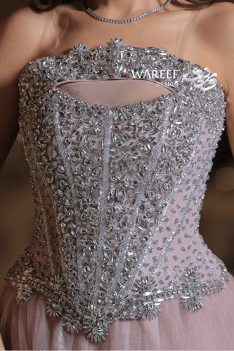 فستان سهرة وردي فاتح بتطريز فضّي كريستالي فاخر وقص...