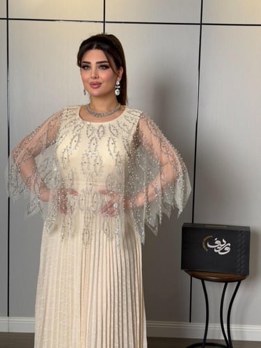 فستان ناعم عاجي فاخر بتطريز كريستالي وأكمام شيفون...
