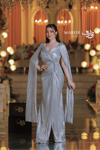 فستان سهرة فضي لامع بأكمام طويلة وتصميم درامي