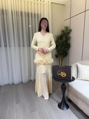 فستان كريمي أنيق بتفاصيل ورود بارزة وقصّة أنثوية ر...