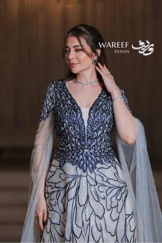 فستان سهرة طويل قماش تول ولون بيج فاتح بتطريز أزرق...