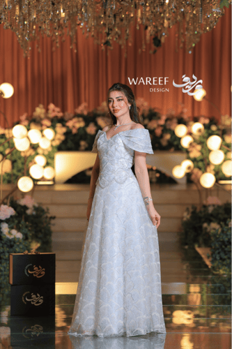 فستان سهرة ملكي فضّي بلمعة كريستالية وتصميم أكتاف...