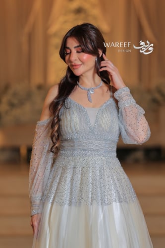 فستان سماوي فاتح مع فتحه بالكتف مزين بالفصوص اللام...