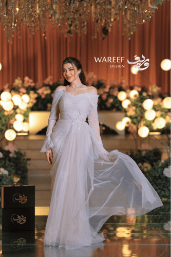 فستان عاجي ناعم بتصميم أكتاف منسدلة ودانتيل راقٍ ب...