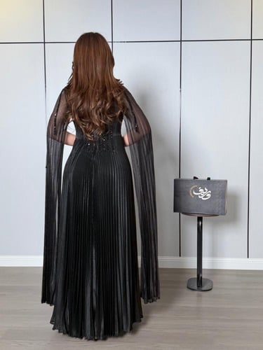 فستان كاب أسود بطيات فاخرة ولمسة براقة