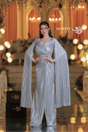 فستان سهرة فضي لامع بأكمام طويلة وتصميم درامي