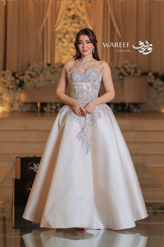 فستان ابيض لؤلؤي بدون اكمام مزين بالشك الفخم