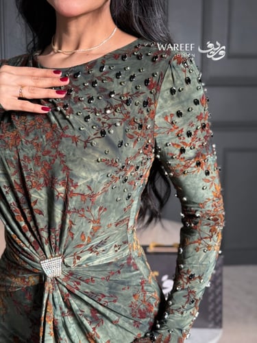 فستان أخضر داكن بنقشة زهرية دافئة وتفاصيل أنثوية ر...